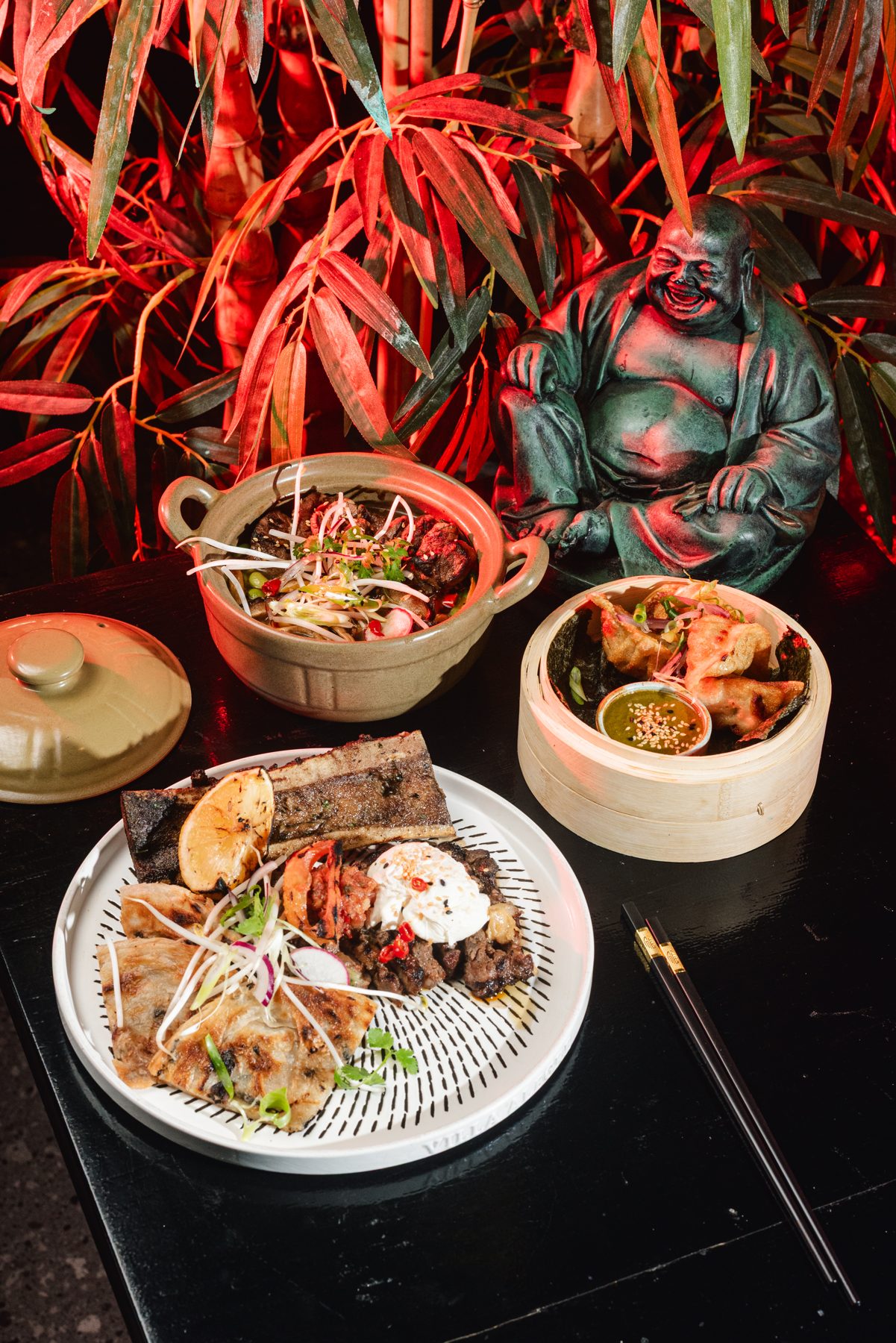 Chunky Chau pan-Asian dining room — moody emerald and rattan interior, Sandton